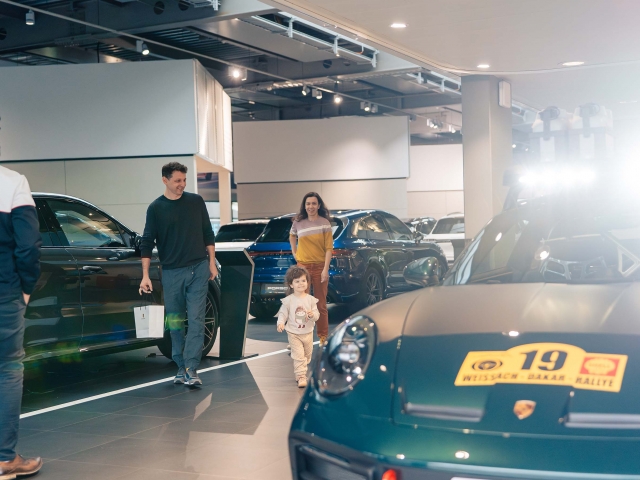 Family-laughing-next-to-the-Porsche-Dakar-in-dark-green