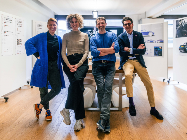 two-women-and-two-men-standing-laughing-at-a-meeting-table