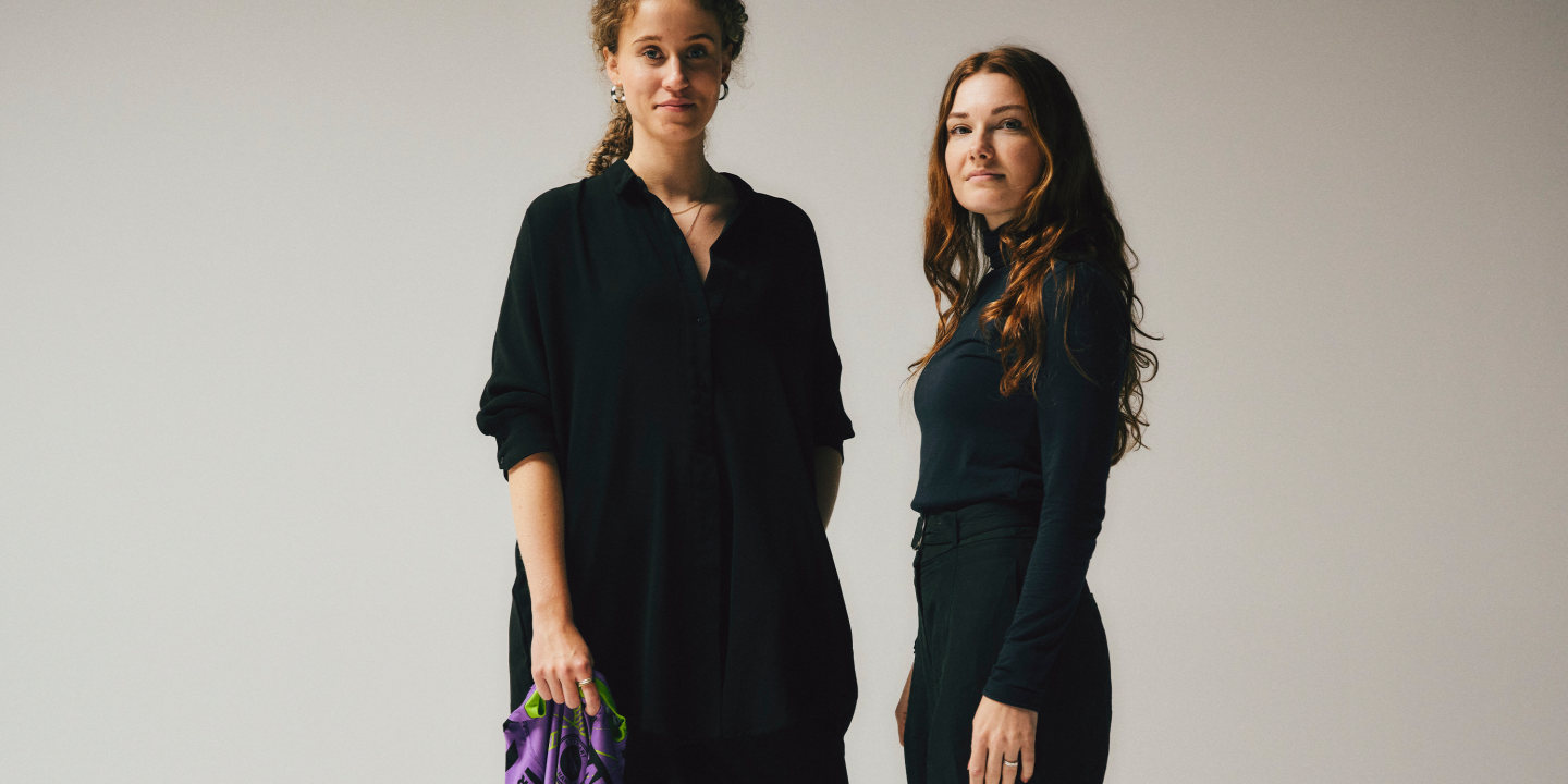 two-women-looking-directly-at-kamera-dressed-black-one-is-holding-jersey-from-tvb-stuttgart
