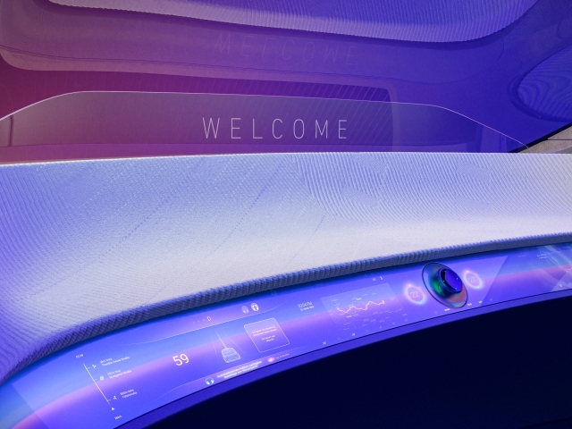 holistic-interior-in-purple-with-continuous-screen-showing-ui-design-in-the-middle-stands-welcome-on-glass-above-center-console