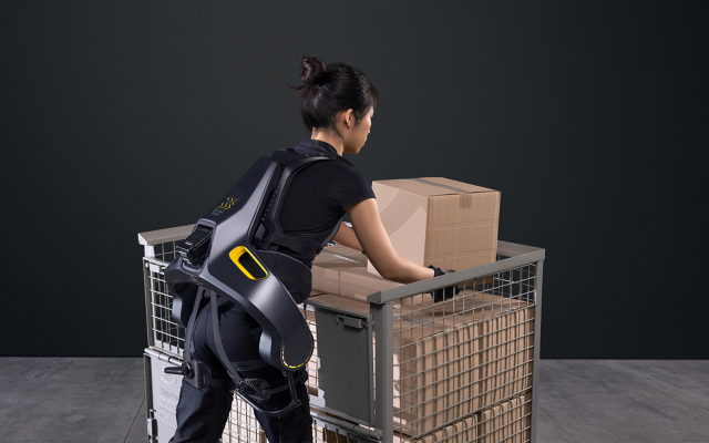 woman-lifts-package-out-of-box-supported-by-the-apogee-exoskeleton
