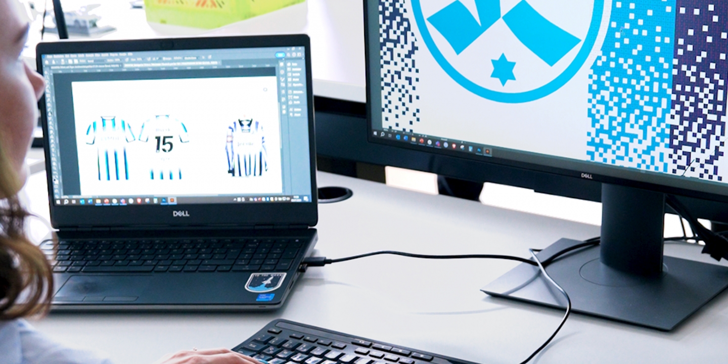 a-young-woman-is-slightly-visible-on-the-left-she-is-looking-at-two-screens-with-material-and-logos-of-stuttgarter-kickers-on-them