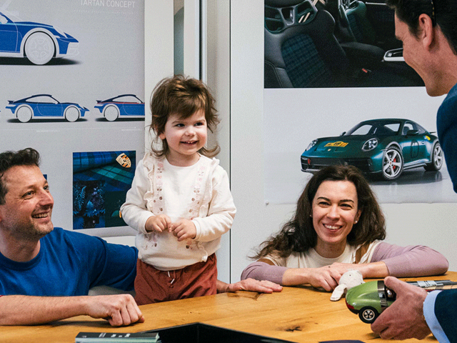 laughing-family-in-the-briefing-room-Porsche-Dakar-pictures-in-the-background